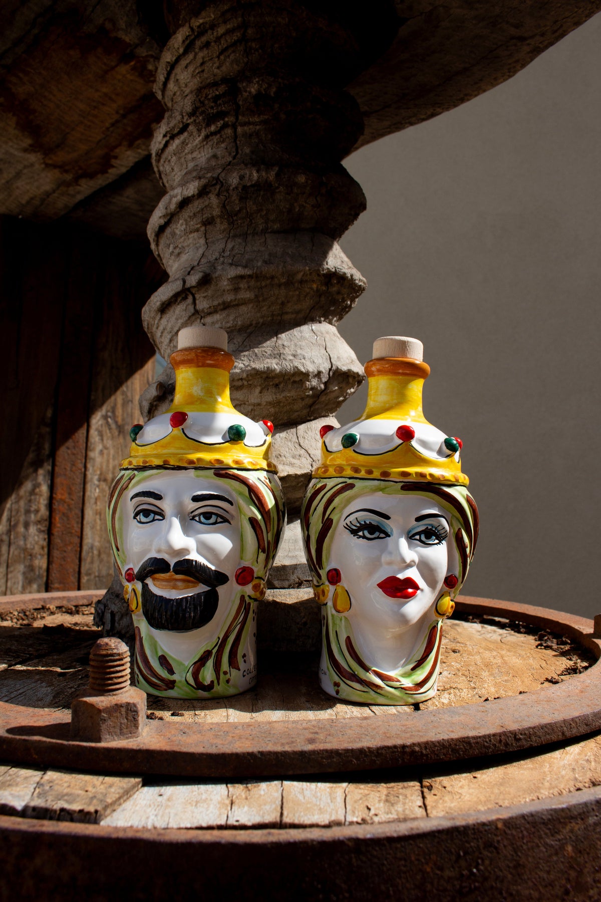 La coppia di teste di Moro Frantoi Cutrera in ceramica di Caltagirone su una macina di frantoio